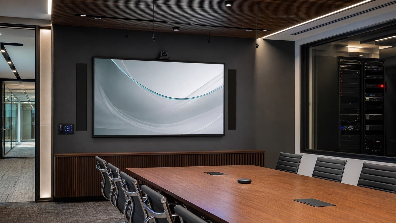 Commercial AV installation with conference display, video conferencing, speakers, access control, and equipment rack