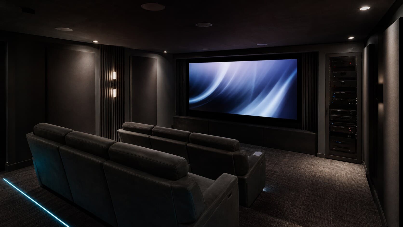 Integrated media room with mounted display, soundbar, speakers, concealed wiring, and AV equipment