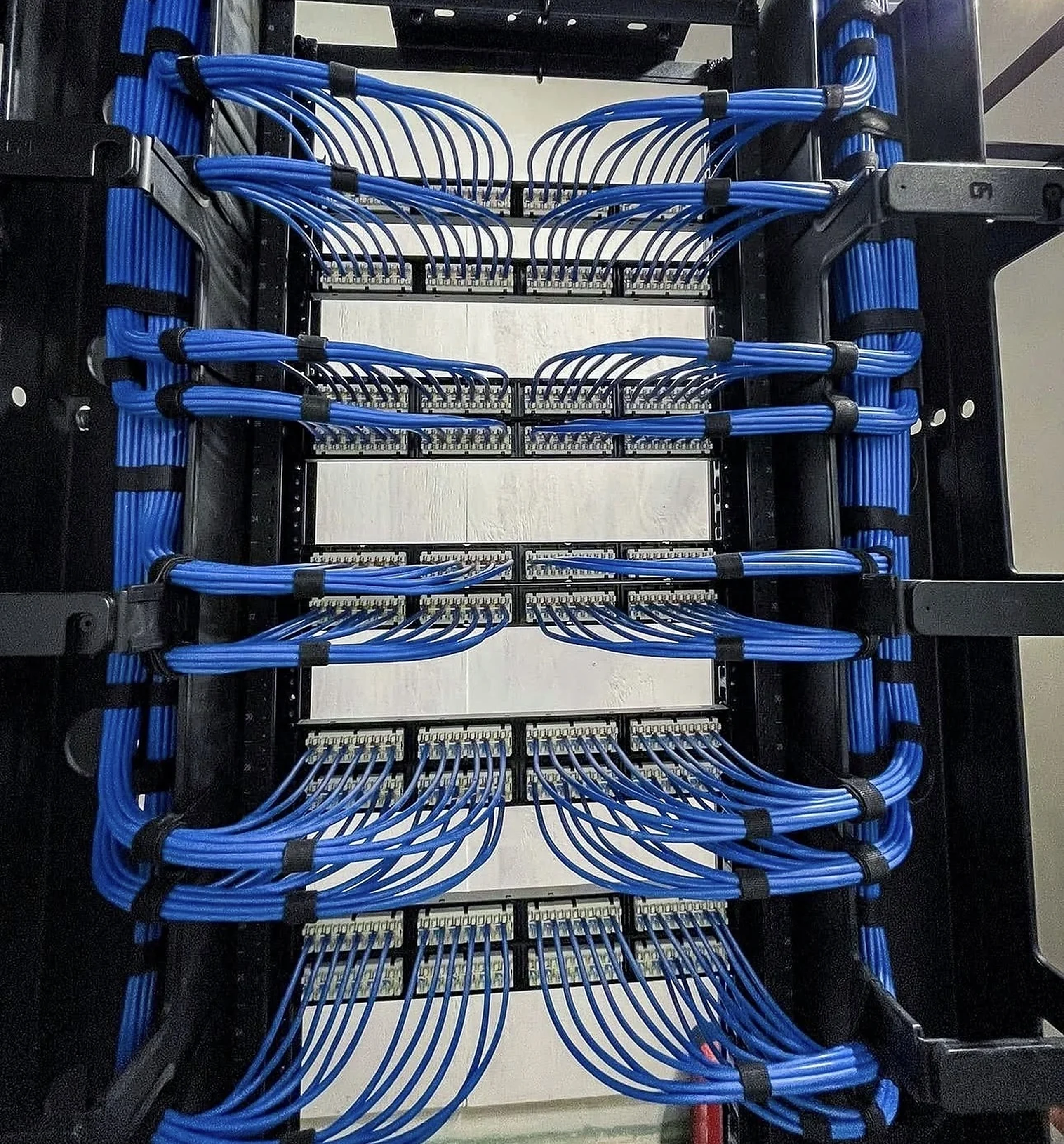 Real finished network rack with neatly dressed blue patch-panel cabling