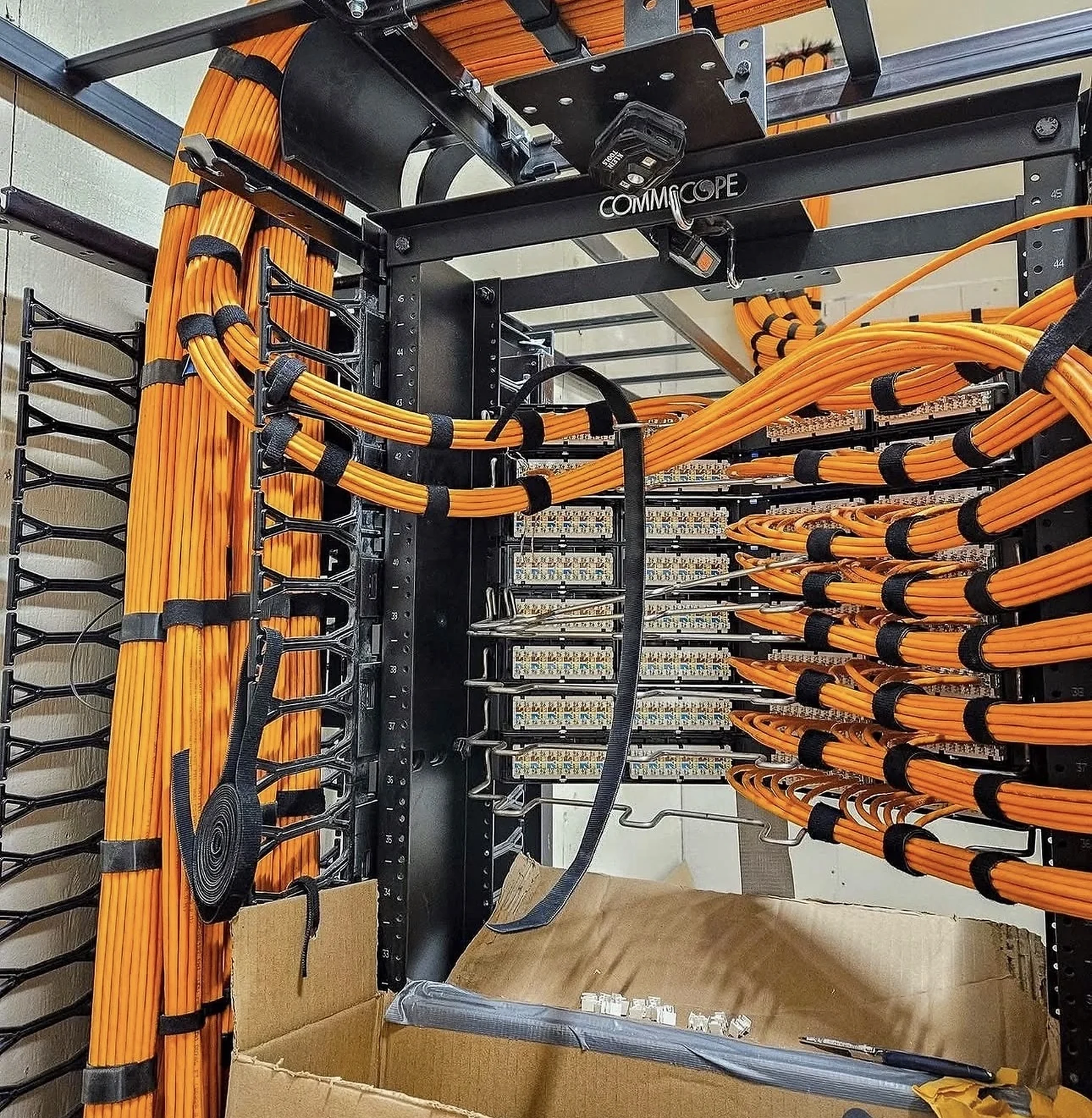 Real commercial equipment rack with organized orange patch-panel cabling